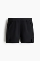 Short deportivo negro confeccionado en tejido funcional con tecnología DryMove. Cuenta con cintura elástica con cordón ajustable oculto, bolsillos laterales, detalles reflectantes y aberturas laterales en el bajo.