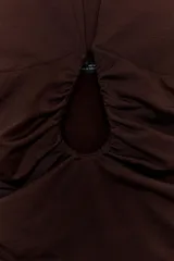 Body de cuello halter con espalda descubierta, confeccionado en poliamida. Presenta un diseño drapeado en los laterales y una abertura frontal con detalle metálico. Posee cierre con botones a presión en la parte inferior y lazada en el cuello.