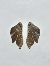 Par de aros con forma de hoja color dorado, con detalle de strass en el centro.