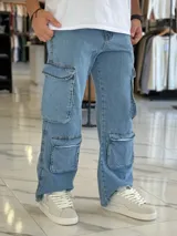 Pantalón de jean estilo cargo, color azul, de corte ancho y holgado, con múltiples bolsillos laterales en muslos y pantorrillas.