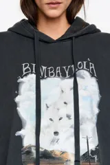 Hoodie de algodón color negro con efecto lavado, corte oversize y capucha con cordones ajustables. Presenta un estampado gráfico frontal con paisaje, lobos y rayos, junto con el logo de la marca.