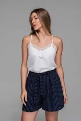 Short sastrero azul marino con finas rayas verticales blancas, de tiro alto y corte holgado. Incluye lazo del mismo tejido para ajustar en la cintura y bolsillos laterales.