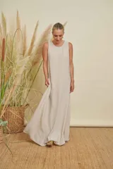 Vestido largo color beige claro, sin mangas y con cuello redondo.