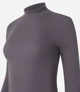 Remera blanca de algodón con cuello alto y mangas largas. Diseño ajustado al cuerpo y textura acanalada.