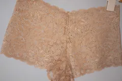 Short de tiro medio confeccionado en puntilla elastizada color beige claro, con diseño floral y fundillo de algodón 100%.