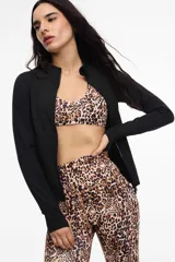 Campera deportiva de cuello alto con cierre frontal de doble cursor. Presenta un corte ajustado que realza la silueta, bolsillos laterales con cierre y mangas largas con puños con abertura para el pulgar.
