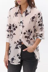 Camisa de mujer color natural con estampado floral en tonos oscuros, cuello clásico, cierre de botones frontal y mangas largas.