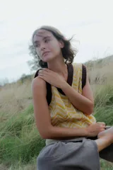 Chaleco de punto sin mangas con escote en V, presenta un diseño estampado geométrico en tonos amarillo y blanco con terminaciones en color marrón oscuro.