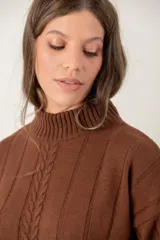 Buzo de punto color chocolate con cuello alto, mangas largas y diseño de trenzas verticales. Presenta puños y ruedo acanalados.