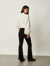 Pantalón de jean negro de corte flare, con tiro medio y bolsillos delanteros y traseros.