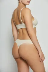 Top de estilo deportivo confeccionado en tejido seamless, con breteles finos y escote redondeado. Presenta un diseño minimalista y ajustado con el logo de la marca estampado en el bajo busto.