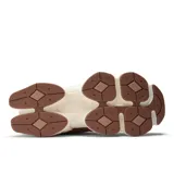 Championes urbanos New Balance modelo 9060, en tonos marrón y beige, confeccionados con capellada de malla y superposiciones de gamuza, con entresuela gruesa esculpida y el característico logotipo "N" en los laterales.