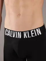 Pack de tres boxers tipo brief de algodón con cintura elástica distintiva de la marca Calvin Klein. Incluye un modelo negro, uno blanco y uno color salmón, todos con el logo estampado en la banda elástica.