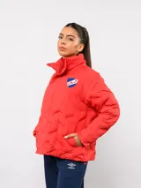 Campera puffer corta de Umbro para el Club Nacional de Football, color azul marino con diseño termosellado. Cuenta con cuello alto, cierre frontal con botones a presión, bolsillos laterales y logo de la marca junto al escudo del club en el pecho.
