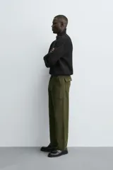 Jersey negro de punto perlado con cuello perkins y cierre frontal de cremallera.