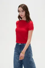 Remera de manga corta color rojo, entallada al cuerpo y con cuello bote, confeccionada en poliéster con textura sutil.