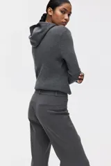 Pantalón sastrero de tiro alto con corte acampanado y pliegues frontales. Cuenta con cierre de botón y bolsillos decorativos.