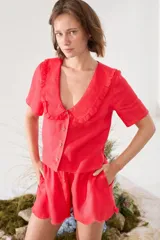 Blusa de lino color rojo, con mangas cortas, cuello en V con solapa redonda fruncida y cierre frontal de botones.