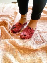 Pantuflas rojas con estampado batik de hojas.