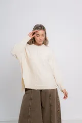 Sweater crudo de punto, con cuello redondo, corte holgado, terminaciones acanaladas en puños y ruedo, y costura central como detalle.
