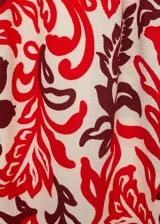 Pantalón largo de corte recto y tejido fluido, con estampado paisley en tonos rojo, bordó y crudo. Cuenta con cintura elástica con cordón ajustable y bolsillos laterales.