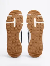 Zapatillas Tommy Hilfiger de running, color azul marino, con exterior de punto y poliéster, suela de goma blanca y detalles distintivos de la marca en el talón.