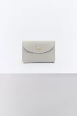 Monedero pequeño de cuero color celeste con cierre de broche dorado.