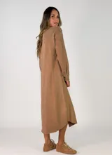 Vestido camisero midi de corte recto y holgado, con cierre frontal de botones, cuello camisero, mangas largas con puños abotonados y bolsillos frontales superiores con solapa.