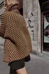 Chaqueta de punto con estructura, corte oversize, cuello solapa, manga larga, bolsillos delanteros y cierre frontal con botones.
