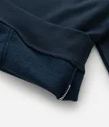 Hoodie azul marino de algodón con felpa y capucha ajustable con cordón. Presenta bolsillo tipo canguro, puños y dobladillo acanalados, y estampa lettering frontal con la leyenda "Coastal Flow".