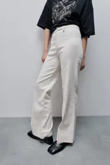 Pantalón de jean azul marino, de tiro alto y calce ajustado con pierna recta levemente amplia, bolsillos traseros y recortes verticales en el delantero.