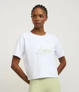 Remera cropped deportiva color blanco, confeccionada en modal, con cuello redondo, mangas cortas y estampado frontal con la palabra "League" en verde claro.