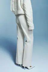 Pantalón de tiro alto confeccionado en pana de algodón, con diseño acampanado, bolsillos de parche frontales y pliegues marcados en el frente y la espalda.