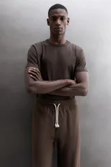 Pantalón jogger relaxed fit de Zara Athleticz confeccionado en tejido de algodón color marrón, con cintura elástica ajustable mediante cordón en contraste, bolsillos laterales y bajo con puño elástico.