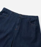 Bermuda tipo jorts de corte amplio y tiro medio, confeccionada en denim de algodón azul oscuro. Presenta diseño de cinco bolsillos, cierre frontal con botón y costuras en tono contrastante.