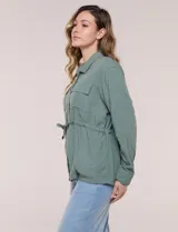 Sobrecamisa beige de lino liviano, con cuello camisero, cierre frontal de botones carey y bolsillos en el pecho. Cuenta con cordón ajustable en la cintura y mangas largas.