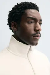 Sudadera roja de corte regular, con cuello alto y cierre frontal de cremallera. Manga larga y terminaciones en rib.