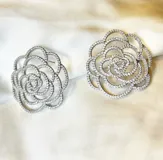 Par de aros plateados con forma de flor calada con incrustaciones de zirconia.