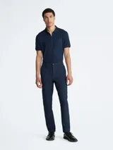 Pantalón chino de hombre, color azul marino, de corte slim y tiro medio. Presenta cierre frontal con botón y cremallera, trabillas para cinturón y bolsillos laterales y traseros.