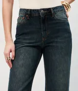 Pantalón de jean Marfinno de corte recto y cintura alta, confeccionado en algodón. Presenta un diseño con pretina con presillas, cierre tradicional con botón y cremallera, bolsillos funcionales y un distintivo ruedo con vuelta fija en tono contrastante.