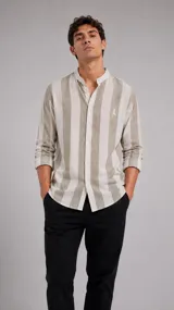 Camisa de manga larga con cuello mao y rayas verticales en color beige y blanco. Cuenta con cierre frontal de botones y bordado sutil en el pecho.