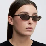 Lentes de sol con montura ovalada de diseño retro y minimalista, en color marrón chocolate con lentes polarizadas a tono.