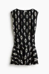Vestido mini negro sin mangas, con estampado geométrico en tonos blancos, escote redondo fruncido, cintura drapeada y falda escalonada con volados.