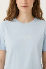 Remera celeste de manga corta con estampa en la espalda de flores y la leyenda "Summer Surf Sessions".