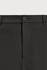 Pantalón regular fit color negro de corte recto, con cintura elástica en los laterales, trabillas, bolsillos frontales y cierre con botón y cremallera.