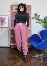 Pantalón de corte holgado y estilo japonés, color rosa, confeccionado en poliéster. Presenta cintura elástica con un aplique decorativo de acrílico en el frente y bolsillos laterales.