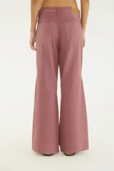 Pantalón de jean color rosado viejo, de tiro alto y corte flare acampanado con bolsillos delanteros y traseros.