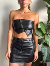 Top strapless de cuerina color negro con cierre dorado en el frente.