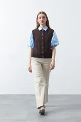 Chaleco tejido de punto color marrón oscuro, con botones frontales y diseño de punto calado vertical.