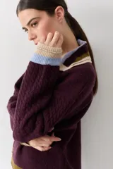 Buzo de lana tipo polo con cuello y cartera de botones en colores contrastantes. Presenta mangas con textura de ochos y puños y ruedo con terminaciones en franjas de colores.